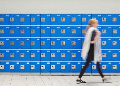 woman walking in front of lockers at pool